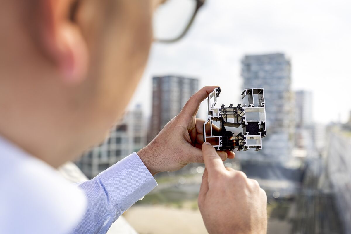Man holding and pointing at aluminium section sample.