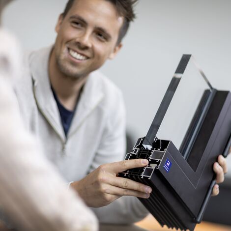 Man holding corner sample of black aluminium window