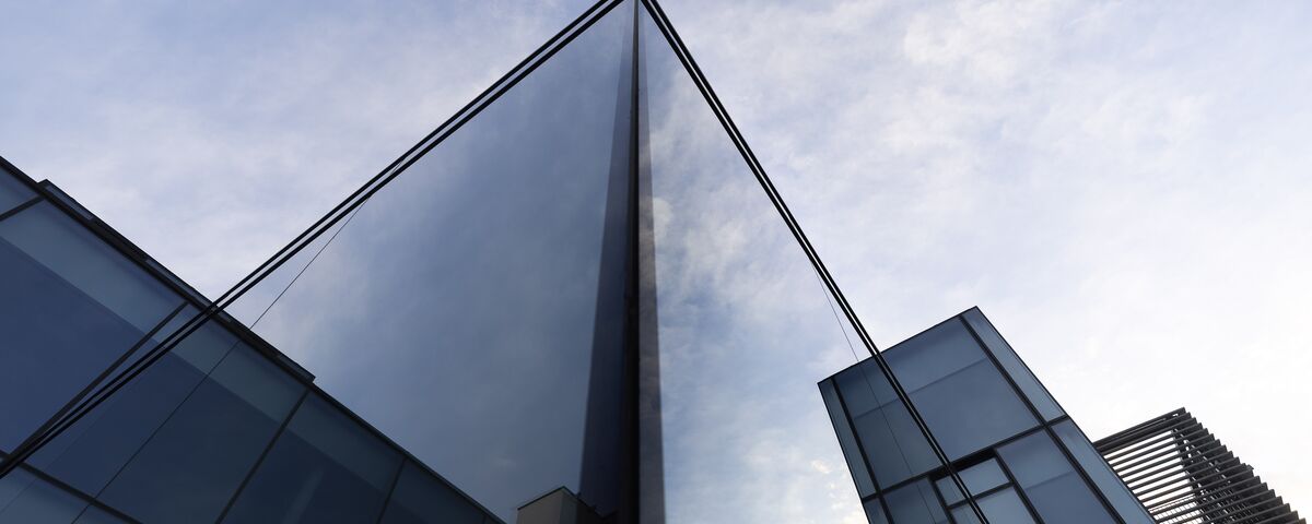 angled view of glass corner façade in modern office building